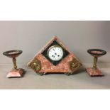 AN ART DECO PERIOD PINK MARBLE AND BRONZE MOUNTED TRIANGULAR CLOCK AND GARNITURE. (38cm x 26cm)