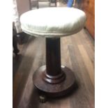 A 19TH CENTURY FRENCH MAHOGANY PIANO STOOL Having a circular upholstered adjustable seat.