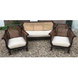 AN EARLY 20TH MAHOGANY BERGÈRE THREE PIECE SUITE With double caned sides and acanthus carved