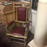 AN EDWARDIAN BEECH WOOD AND MAROON LEATHER UPHOLSTERED STEAMER ROCKING CHAIR.