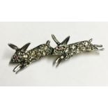 AN EARLY 20TH CENTURY GOLD AND DIAMOND ENCRUSTED BROOCH Formed as two running rabbits, contained