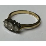 AN 18CT GOLD AND DIAMOND THREE STONE RING Having three graduated round cut stones in a raised