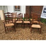 A HARLEQUIN SET OF TEN OAK LADDER BACK DINING CHAIRS With rush seats including two carvers, 19th