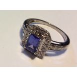 A VINTAGE 14CT WHITE GOLD, TANZANITE AND DIAMOND RING Having a single baguette cut tanzanite held in