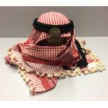 A MID 20TH CENTURY ARABIAN KEFFIYEH With silver metal badge. Condition: good, shows age