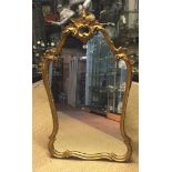 A REGENCY DESIGN GILT WOOD FRAMED MIRROR OF CARTOUCHE FORM Having a silvered plate. (68cm x 108cm)