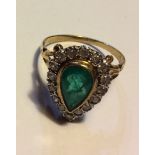 A VINTAGE YELLOW METAL, EMERALD AND DIAMOND RING Having a single pear cut emerald, surrounded by a