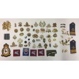 A MIXED LOT OF CAP BADGES AND SEW ON PATCHES.