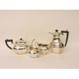 An early 20th century silver three piece tea set, the pot with faceted body ebonised handle and