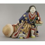 An Imari figure of Okame,c.1890, dragging a large phallic mushroom in her right hand and a basket of