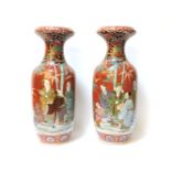 A pair of Chinese vases, c.1880, with an orange ground, with figures beneath bamboo, chipped, 57cm