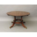 A reproduction mahogany Jupe style dining table, the circular top on four turned column supports,