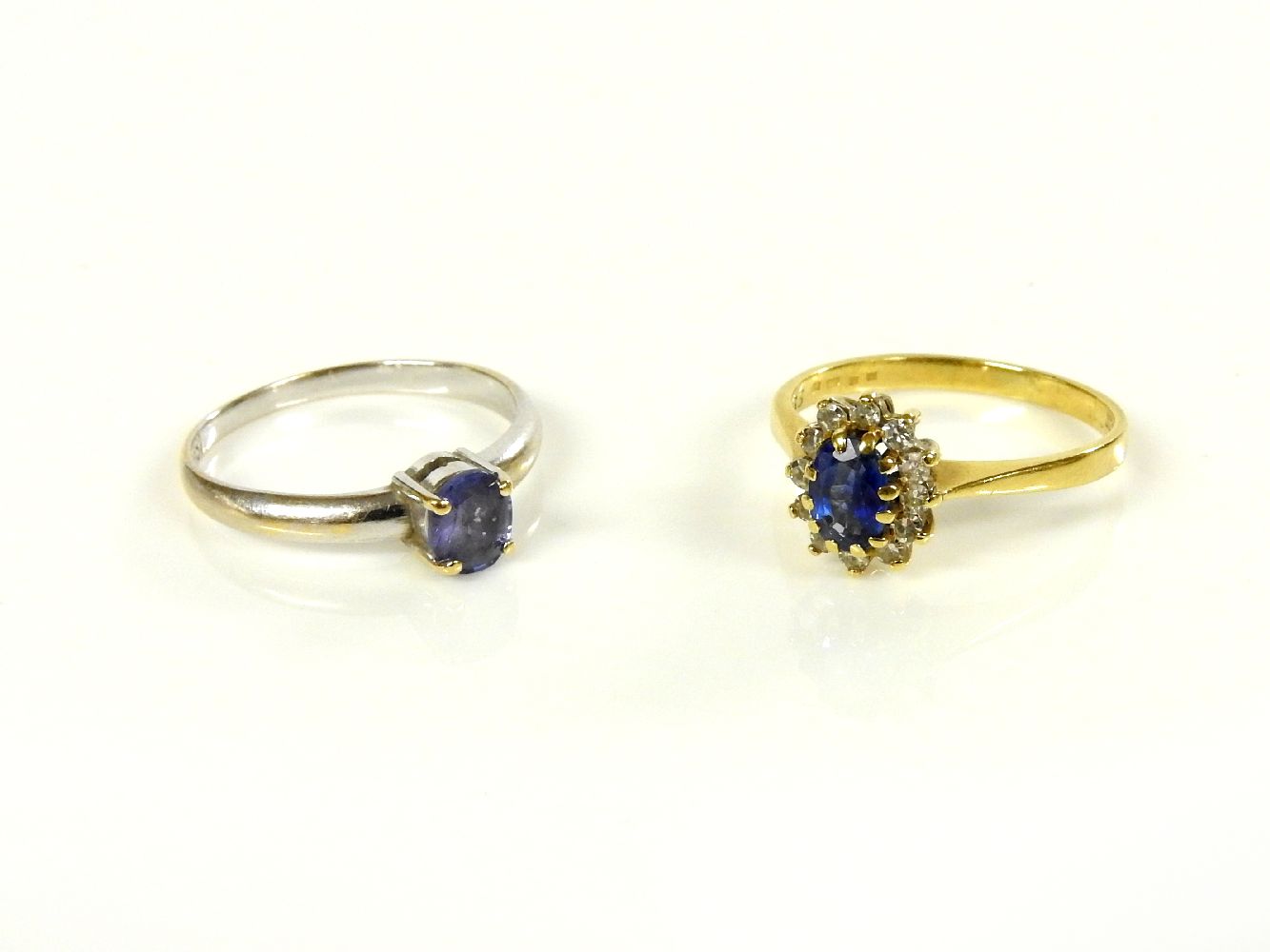 An 18ct gold sapphire and diamond cluster ring, and a white gold single stone tanzanite ring, marked