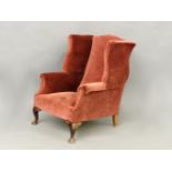 A George III style wing back armchair, standing on short cabriole legs, 81 x 86cm deep