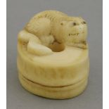 A 19th century ivory netsuke, in the form of a tiger curled around the top of a bamboo section, 3.