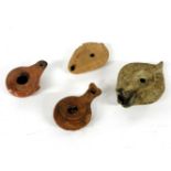 Four various pottery oil lamps, the largest with Gadrooned decoration, 12cm long and three others (