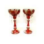 A pair of ruby and gilt candlesticks, with bowl surmount, both with clear glass drops