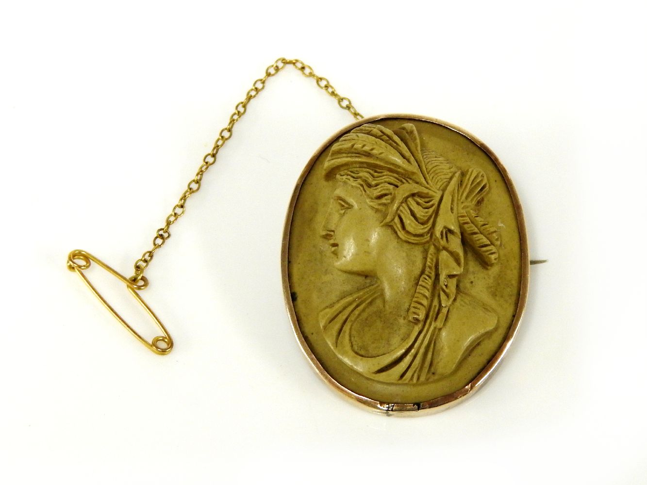 A gold lava stone carved cameo brooch