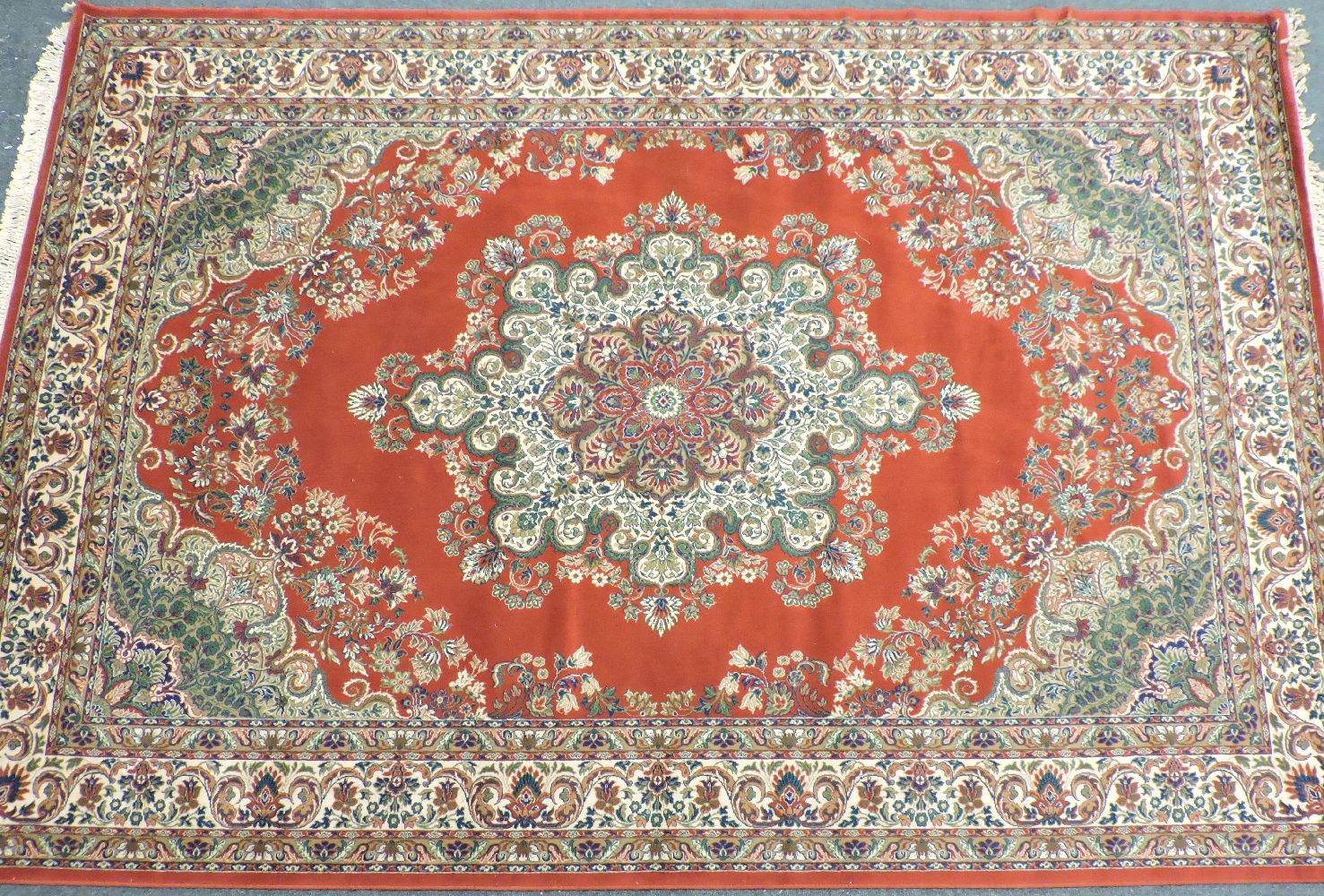 A large red ground Keshan rug, with central foliate medallion within a multiple banded boarder,