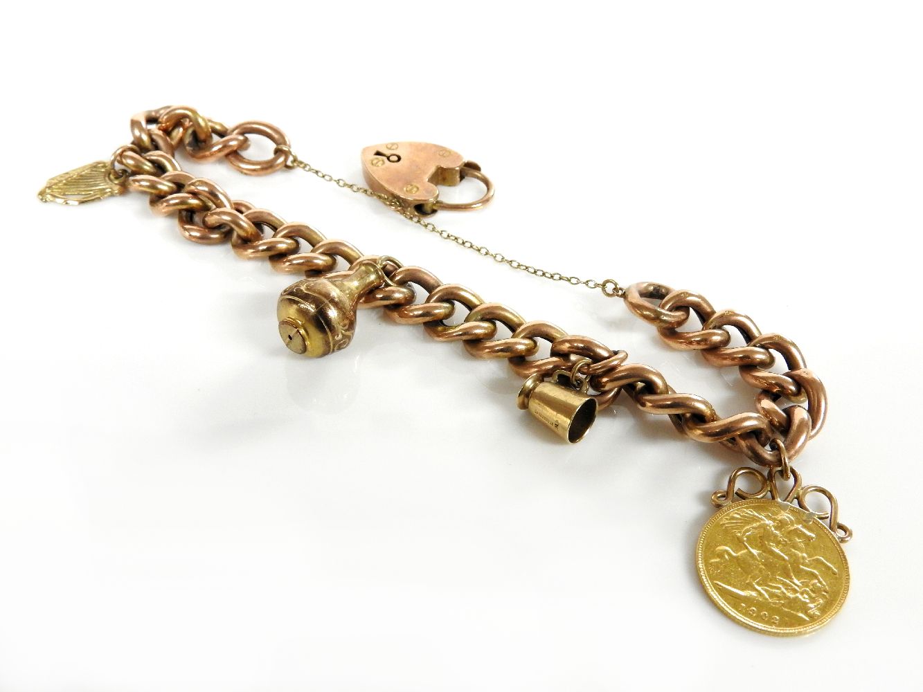 A gold curb bracelet marked 9ct with padlock, together with three 9ct gold charms, and a 1902 half