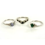 A 9ct white gold three stone sapphire and diamond ring, a white three stone emerald and diamond
