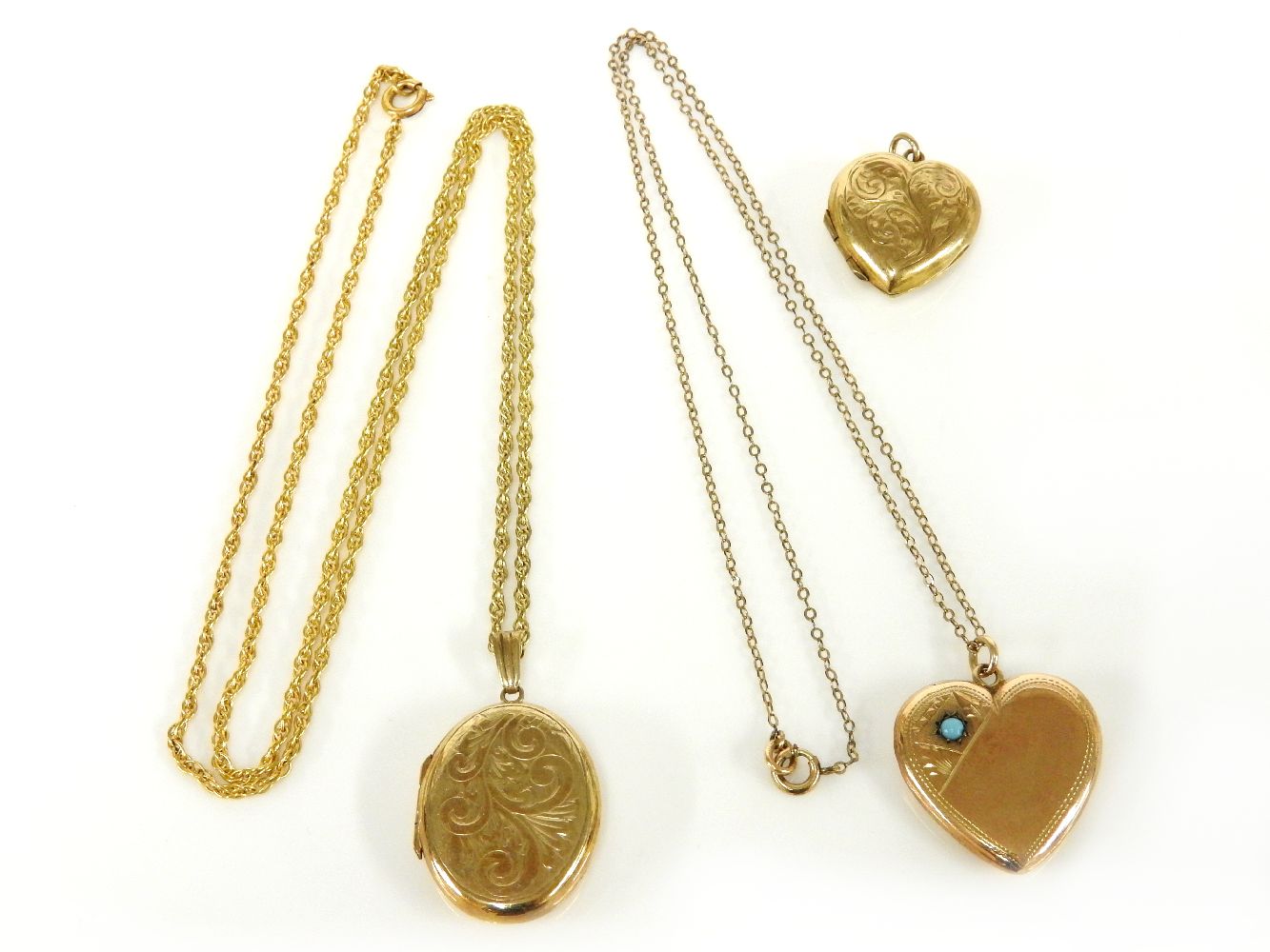 A 9ct gold oval locket, with scroll detail, on a gold plated Prince of Wales chain, a gold heart