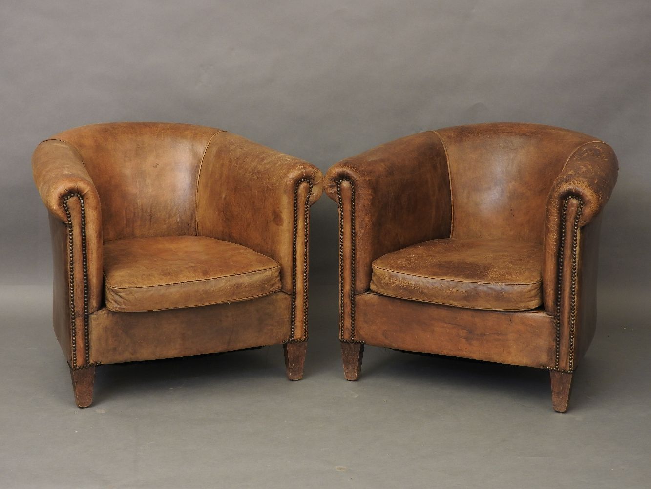 A pair of leather tub chairs, 82cm wide approx