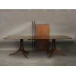 A George III style mahogany twin pedestal dining table, with two spare leaves. 302cm long x 122cm