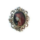 A gold scroll mounted swizzle brooch, with later painted miniature of a young woman with a red