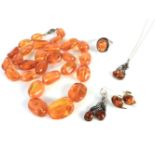 A single row of graduated free form amber beads, a pair of gold amber earrings, marked 375, a pair