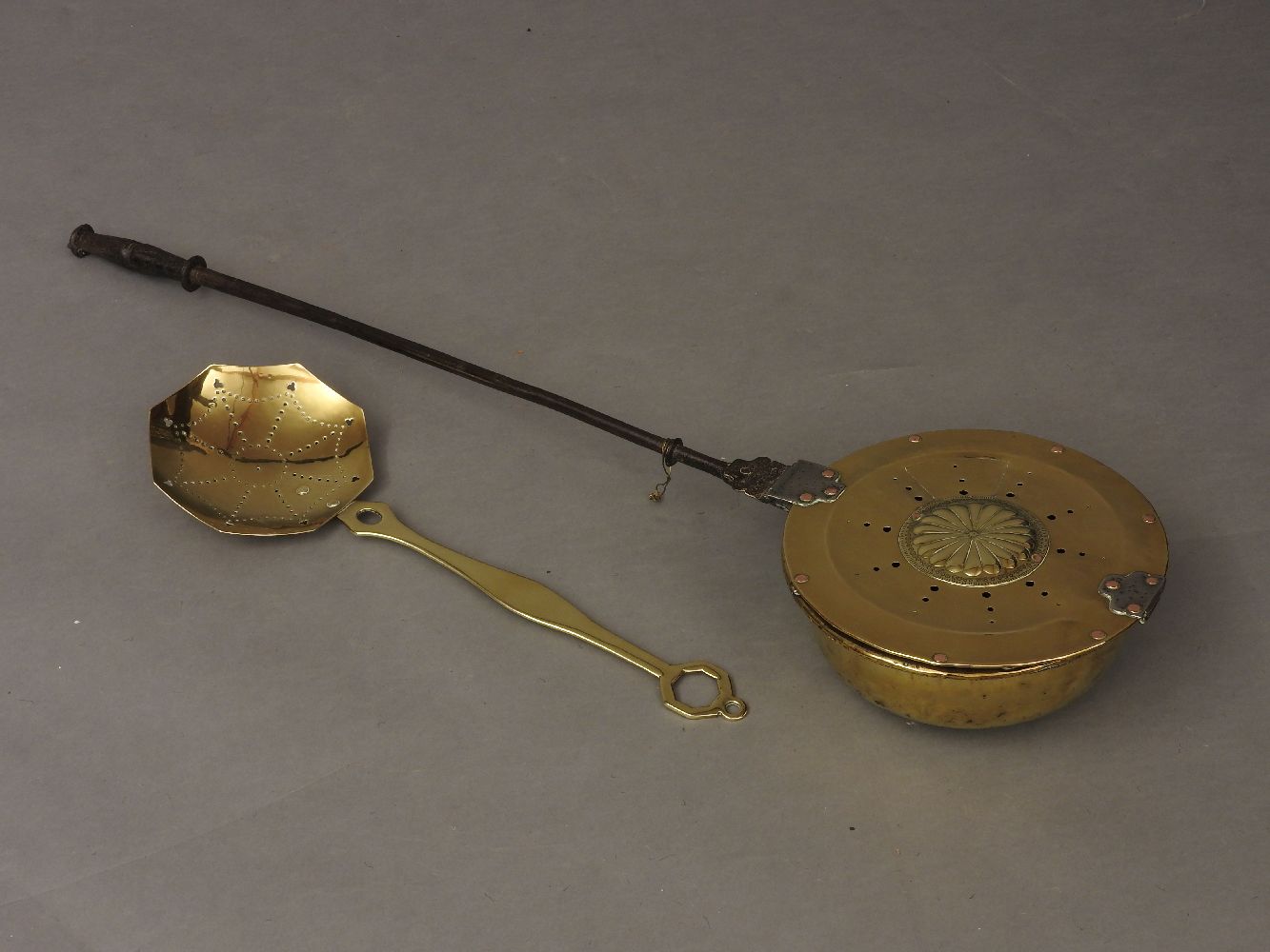 An 18th century brass and steel handled warming pan, 114cm long (later repairs) and a brass skimmer