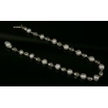 An Art Deco platinum and pearl bracelet with series of faceted platinum beads, strung on wire