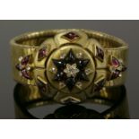 A late Victorian gold diamond and garnet bracelet, c.1880, with a raised central boss, the boss