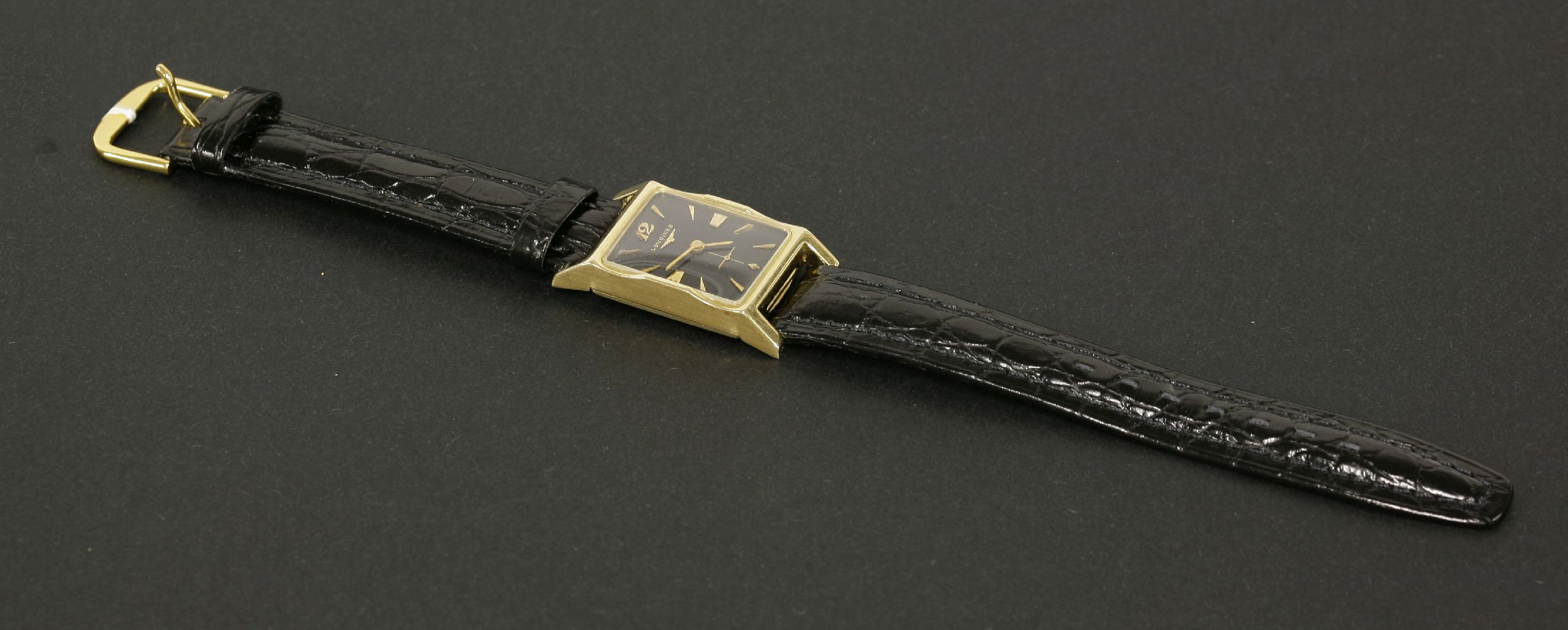 A Longines gold American market mechanical strap watch, with a black enamel dial, gilt hands and