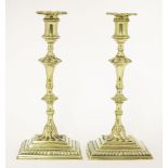 A pair of brass candlesticks,mid-18th century, with square gadrooned bases,25cm high (2)