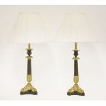 A pair of parcel gilt candlesticks,with reeded columns and cast gilt triform bases, converted into
