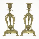 A pair of Regency cast candlesticks,each with a removable drip pan, raised on an eagle and monopedia