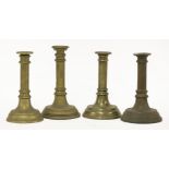 Four early Victorian cast candlesticks,believed to be Military Academy type examples, engraved