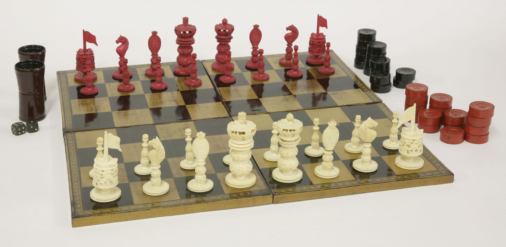 A carved ivory chess set,19th century, stained red and natural,king 8.5cm high,sixteen draughts