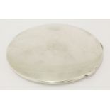 A George V silver compact, London 1933,circular, plain, the hinged cover with gilt interior,10cm