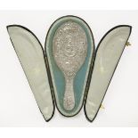 An Indian white metal toilette mirror,Cutch, c.1900, decorated all over with a central figure of