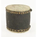 A tribal carved wooden drum,with hide skin to either end, 40cm tall x 40cm diameter