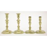 Two pairs of brass candlesticks,early and mid-18th century, each with canted square bases,13 and