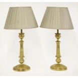 A pair of gilt metal candlesticks,with cast engine turned decoration, converted into table lamps