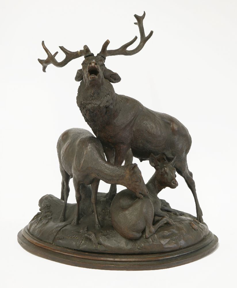 A Black Forest carved deer group, 19th century, the stag with two hinds on a domed base with rocks