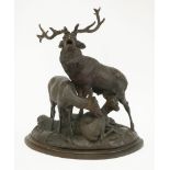 A Black Forest carved deer group, 19th century, the stag with two hinds on a domed base with rocks