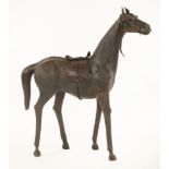 A large model stallion,leather covered, with glass eyes, a saddle and harness,101cm high