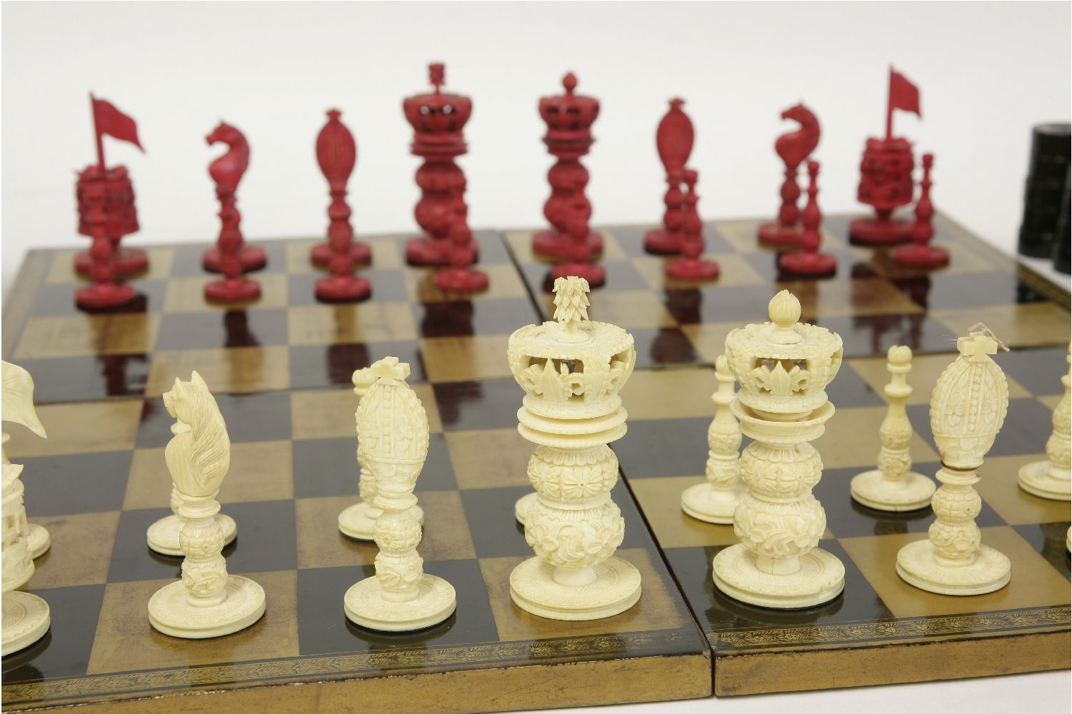 A carved ivory chess set,19th century, stained red and natural,king 8.5cm high,sixteen draughts - Image 2 of 4