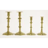 A pair of George II brass petal based candlesticks, the lobed sconces over knopped stems, 23.5cm