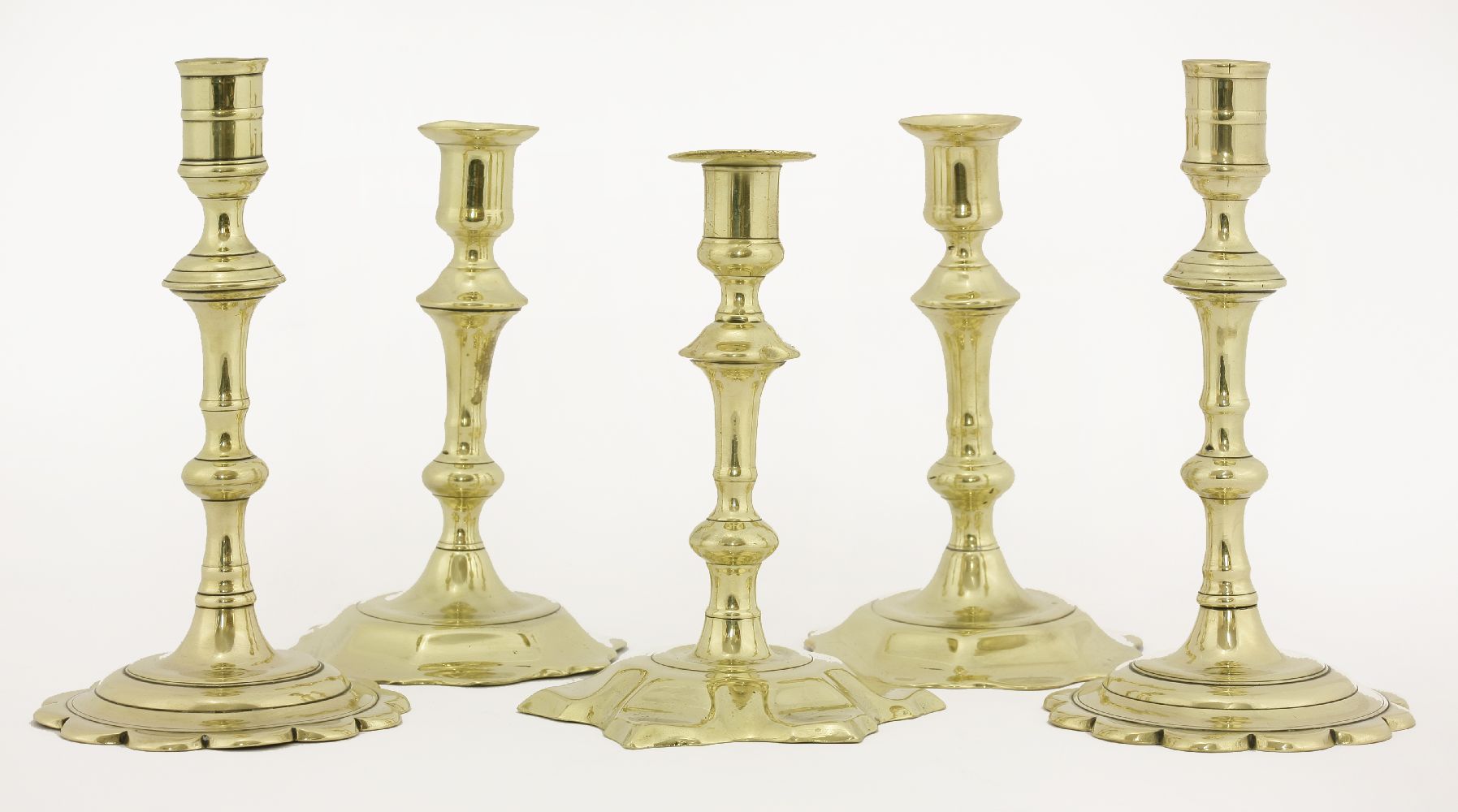 Two pairs of brass candlesticks,mid-18th century, each with petal bases,17 and 19.5cm high,